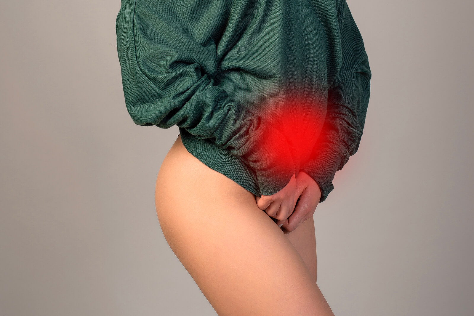 Woman with her hands covering her pelvic area with her hands as she deals with the symptoms of endometriosis. Pelvic Floor Physical Therapy for Endometriosis can help you manage your pain and discomfort.