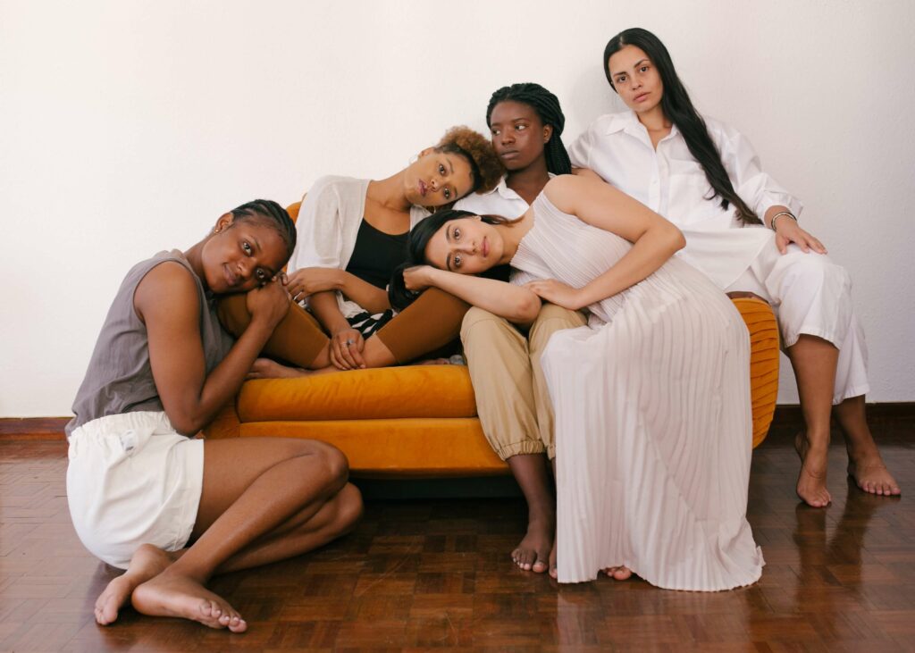 A diverse group of women sitting on a couch in support of each other. Get the support you need for your pelvic pain in Pelvic Floor Physical Therapy in Washington, DC. 