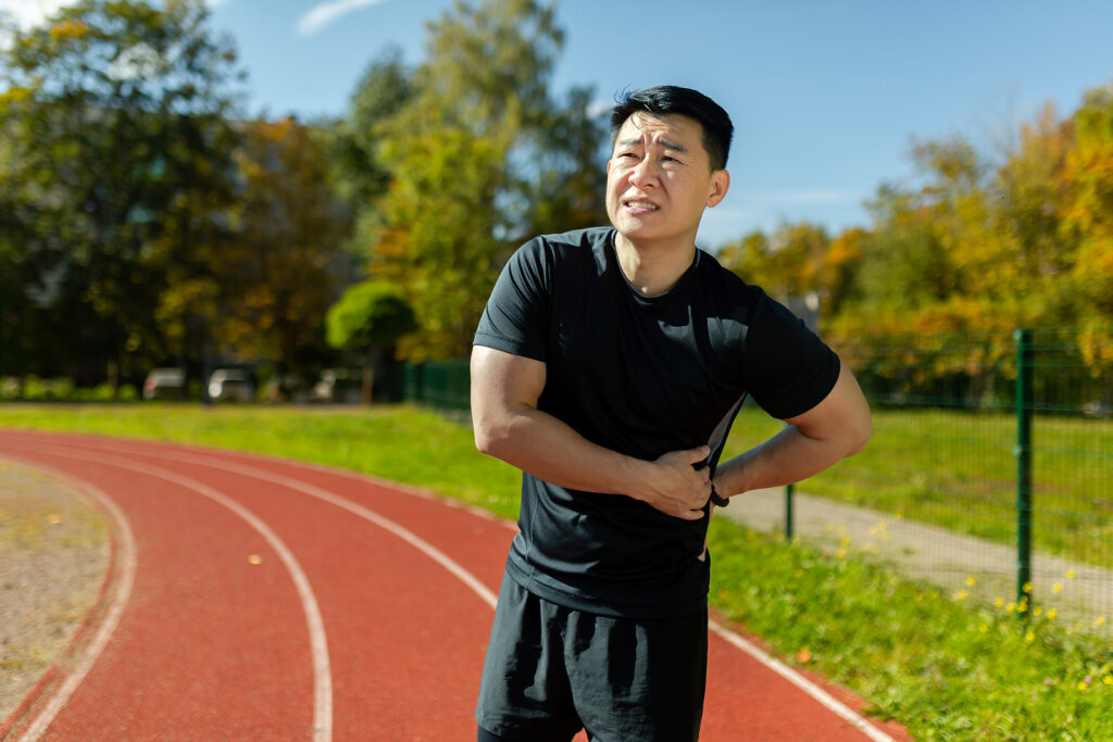 An athlete deals with chronic low back pain in Washington, DC while running on the track. 
